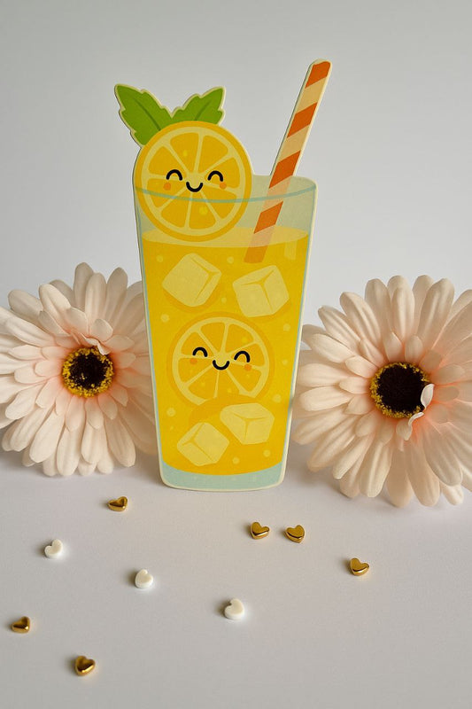 Glass of lemonade with a straw, lemon slices, and ice cubes on a white background with flowers.